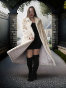 Woman wearing a long white fur coat in an outdoor setting with a building in the background.