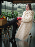 Woman in a fur coat sitting outdoors on a rainy day