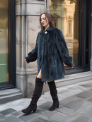 Model walks confidently in The Still Hour deep teal fur coat, showcasing its luxurious texture and timeless silhouette.