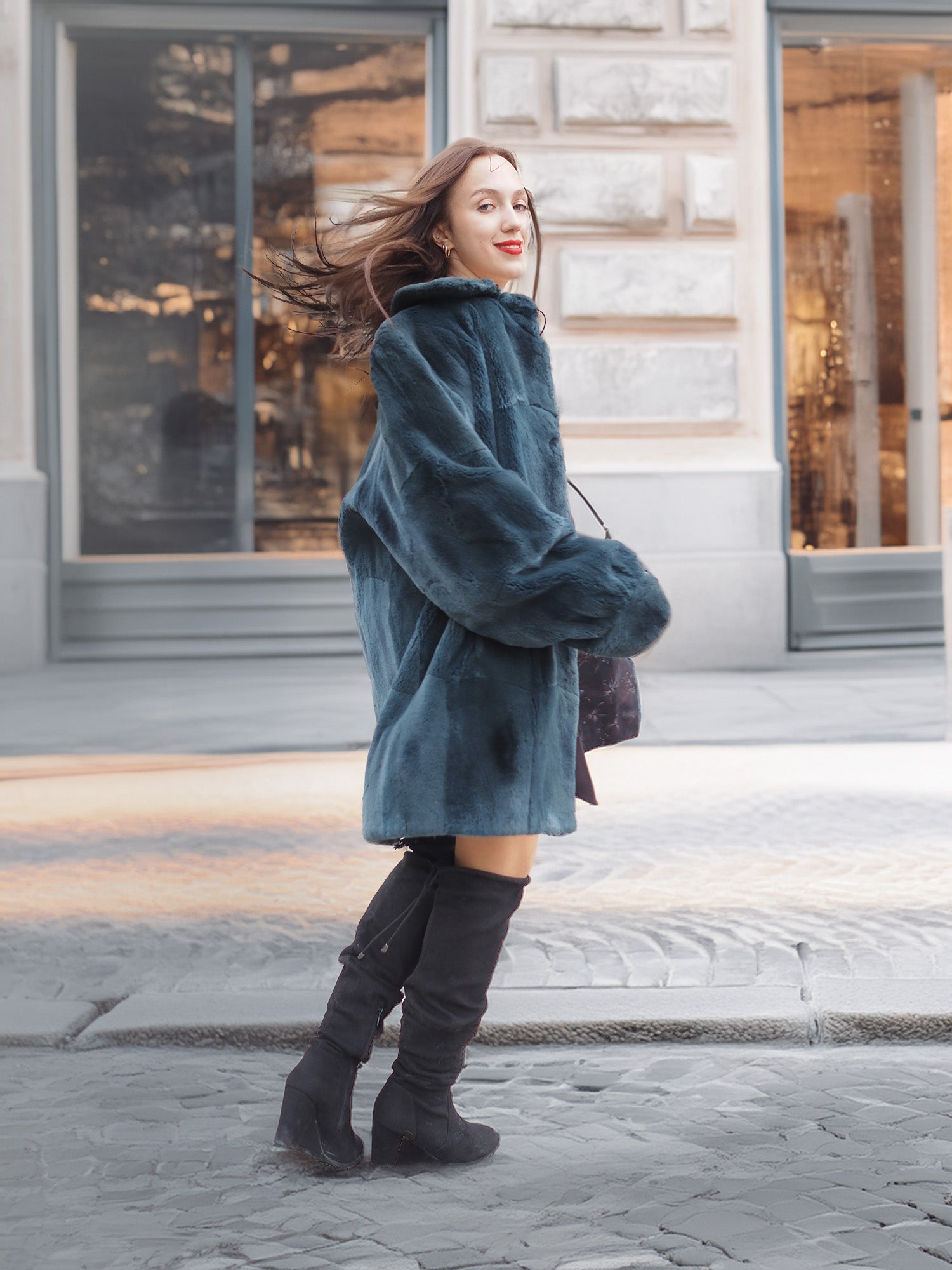 The Still Hour fur coat in deep teal sways as the model walks, highlighting its plush texture and stylish winter-ready design.