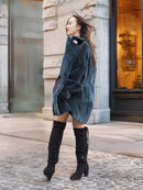 Back view of The Still Hour fur coat in deep teal as the model walks, highlighting its elegant drape and winter-ready design.