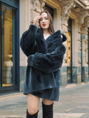 Model poses in The Still Hour deep teal fur coat with oversized sleeves and a vintage button, perfect for luxury winter outerwear.