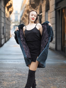 Model opens The Still Hour deep teal fur coat to reveal a black dress, blending vintage elegance with modern winter fashion.