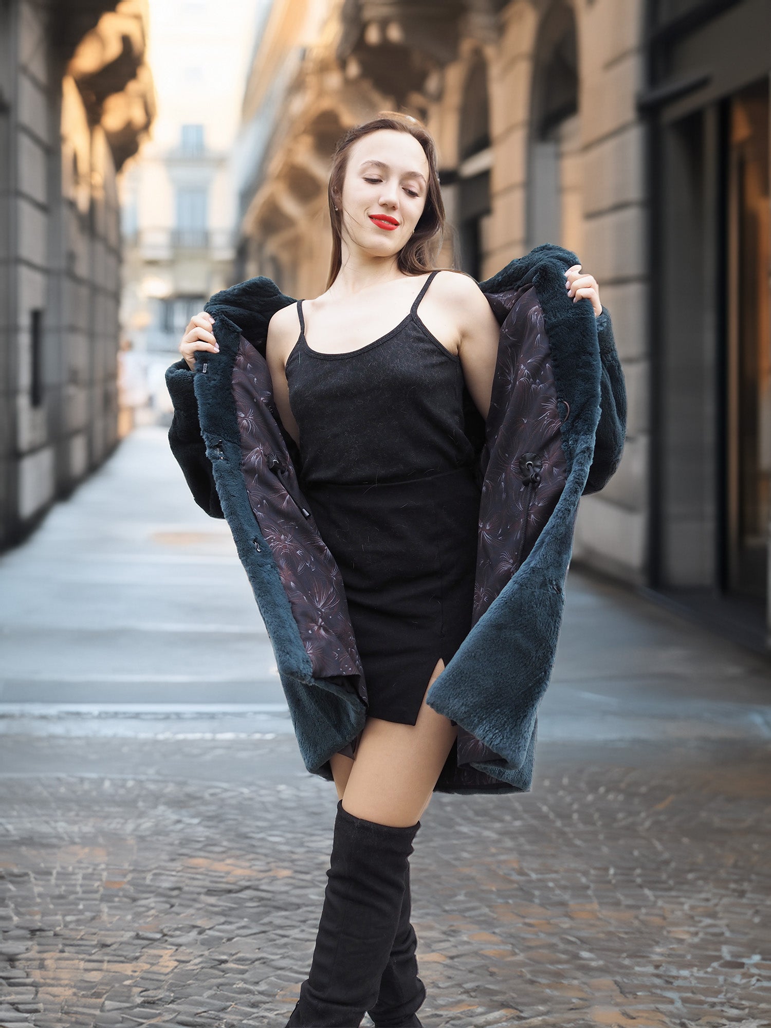 Model opens The Still Hour deep teal fur coat to reveal a black dress, blending vintage elegance with modern winter fashion.