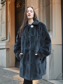 Close-up of The Still Hour sheared muskrat fur coat in deep teal, featuring a single button closure and soft, plush texture.
