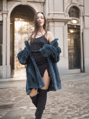 Model reveals black dress under The Still Hour deep teal sheared muskrat fur coat, blending glamour and warmth in luxury outerwear.
