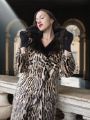 Woman wearing a leopard print coat with a fur collar in an elegant setting.