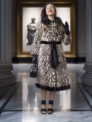 Woman wearing a leopard print coat in an elegant interior setting