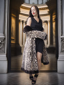 Woman in a black dress with a leopard print coat in an elegant interior setting