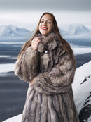 Woman wearing a fur coat with a snowy mountain landscape in the background