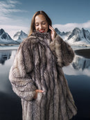 Woman wearing a fur coat with a mountainous landscape in the background