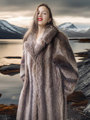 Woman wearing a fur coat with a mountainous landscape in the background