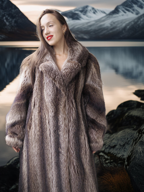 Woman wearing a fur coat with a mountainous landscape in the background