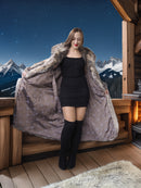 Woman wearing a fur coat in front of a mountainous landscape