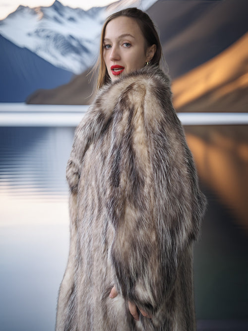 Woman wearing a fur coat with a mountainous landscape in the background