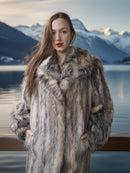 Woman wearing a fur coat with a mountainous landscape in the background