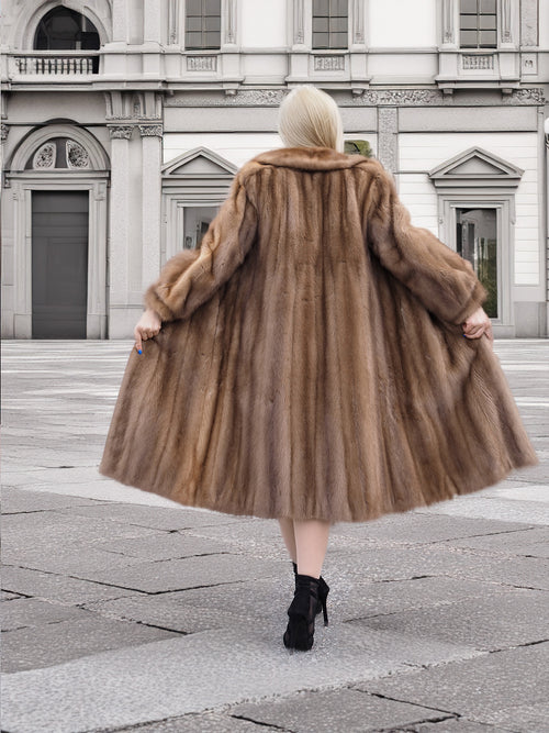 a woman in a fur coat is walking down the street
