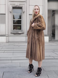 a woman in a fur coat standing on a sidewalk