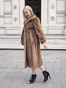 a woman in a fur coat is walking down the street