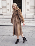 a woman in a fur coat is walking down the street