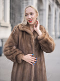 a woman in a fur coat talking on a cell phone