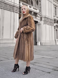 a woman in a fur coat standing on a sidewalk