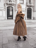 a woman in a fur coat standing on a sidewalk