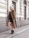 a woman standing on a sidewalk wearing a fur coat