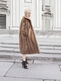 a woman in a fur coat is walking down the street