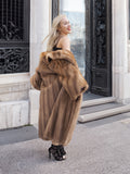 Luxurious brown mink fur coat worn by glamorous woman on ornate steps.