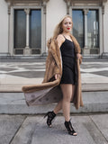 Elegant vintage mink fur coat over stylish black dress, woman posing confidently on steps of grand building