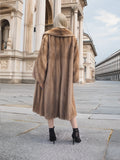 Elegant vintage pastel brown mink fur coat displayed on a city street backdrop.