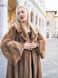 Elegant vintage mink fur coat draped over fashionable woman in historic cityscape.