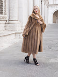 Luxurious vintage pastel Canadian brown mink fur coat with flared sleeves, worn by a woman standing in front of an ornate architectural structure.