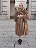 Elegant woman wearing a vintage pastel Canadian brown mink fur coat standing outdoors.