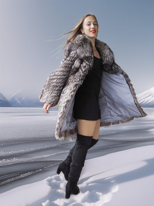 Woman in a fur coat standing on a snowy landscape with mountains in the background
