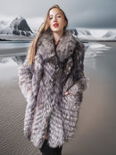 Woman wearing a fur coat with a mountainous landscape in the background