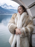 Woman wearing a fur coat with a scenic background of mountains and water.