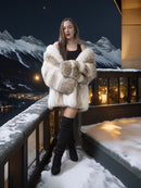 Woman in a fur coat standing on a balcony with snowy mountains in the background