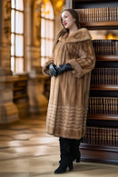 Tan mink fur coat with wide hood, long sleeves, and ribbed lower hem; black gloves