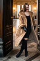Tan mink fur long coat with hood and ribbed hem, styled over a black dress