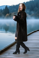 Dark fur button-front coat with stand collar and sleeve cuffs, walking view