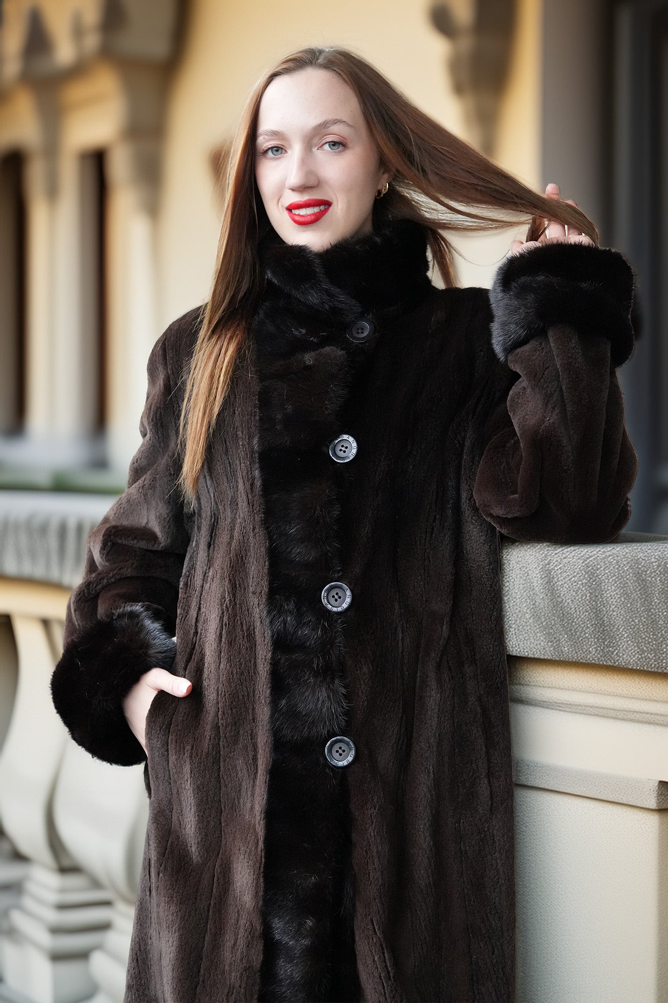 Sheared mink coat with stand collar, dark button front, and fluffy cuffs