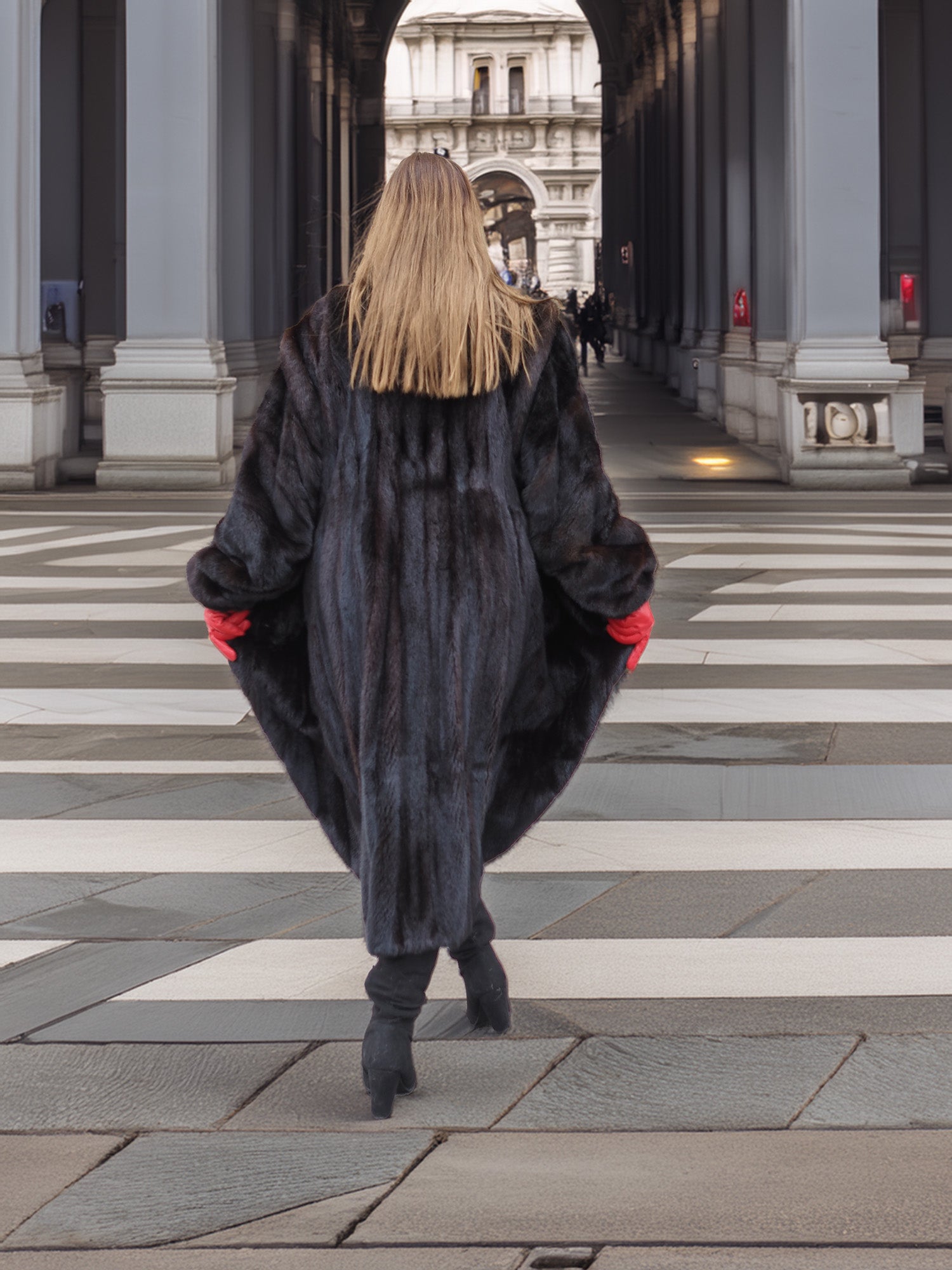 Back view of long black mink fur coat with natural sheen, worn with red gloves and boots. Sophisticated winter outerwear.