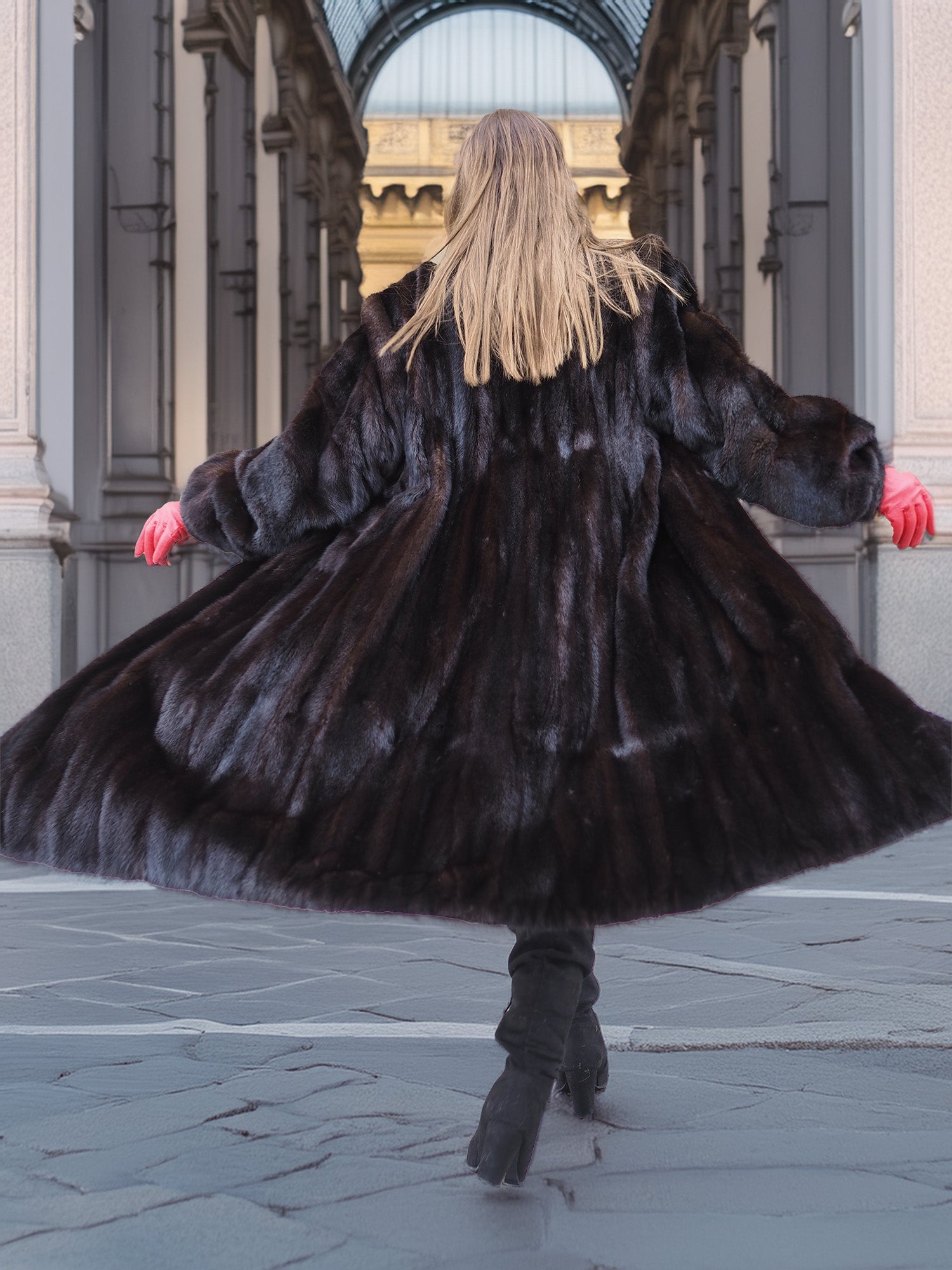 Back view of a swirling black mink fur coat, showcasing the fully let out pelts and voluminous silhouette. Premium fur outerwear.