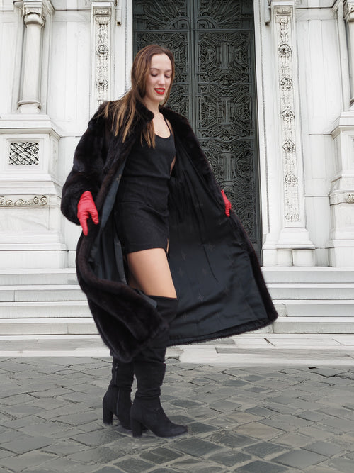 Open view of dark ranch mink fur coat revealing satin lining. Elegant and functional winter outerwear with monogram detail.