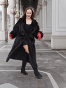 Model twirling in black mink fur coat with red gloves, showing coat’s volume and flow. Premium winter fashion outerwear.