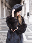 Close-up of black mink fur coat and matching hat, highlighting the plush texture and luxurious craftsmanship. Classic fur fashion piece.