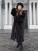 Model posing in front of neoclassical architecture in a dark ranch black mink fur coat and hat. Elegant and timeless winter coat design.