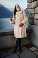 Ivory mink coat with flared hem and red gloves, long buttonless look